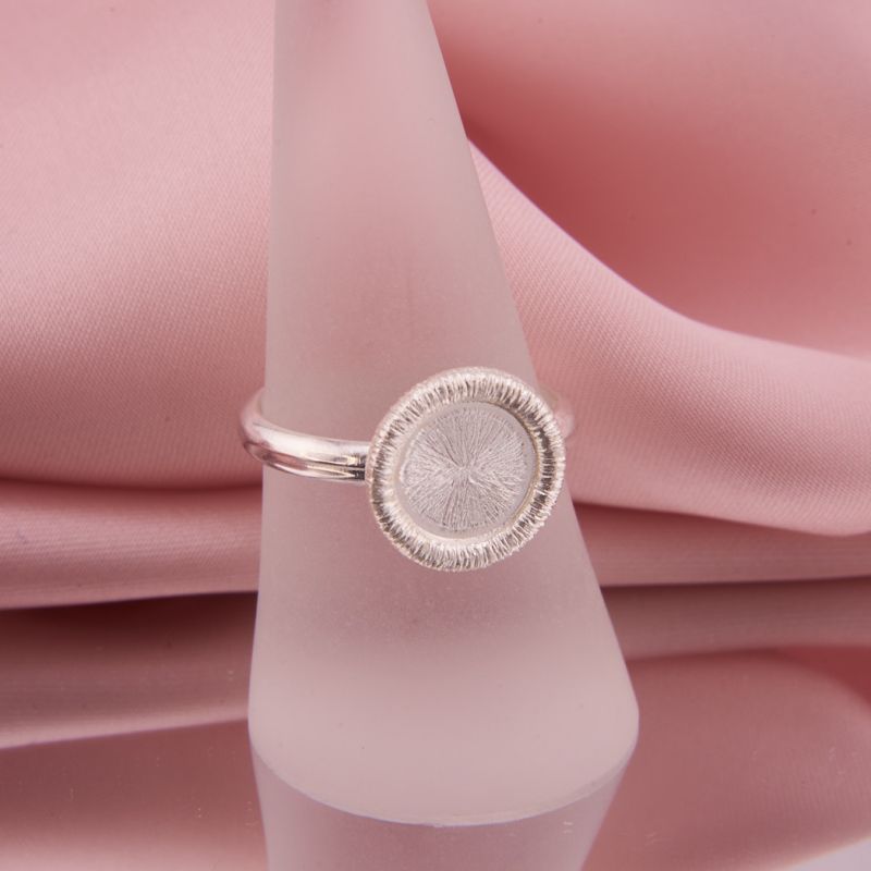 Preview: Nahaufnahme des Silberrings Coletta Facette aus 925 Silber präsentiert auf Ringständer, funkelnde Ronde und Halbrund Ringschiene.